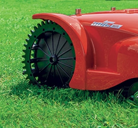 Robotic lawn mower with toothed rear wheels